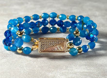 Load image into Gallery viewer, Blue beaded bracelet with gold accents on a gray surface