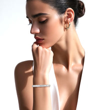 Load image into Gallery viewer, Woman wearing a diamond bracelet and earrings on a neutral background