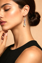 Load image into Gallery viewer, Close-up of a woman wearing a colorful earring against a beige background