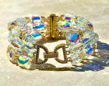 Load image into Gallery viewer, Multicolored beaded bracelet with a gold clasp on a reflective surface