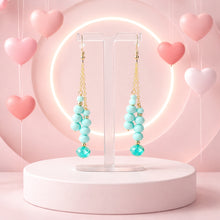 Load image into Gallery viewer, Turquoise beaded earrings on a white stand with a pink heart-shaped background