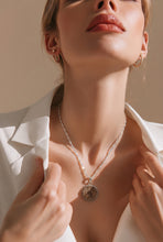 Load image into Gallery viewer, A close-up lifestyle shot of a model wearing a delicate silver chain necklace with a round textured gold drusy pendant, styled with gold hoop earrings and a white blazer.