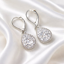 Load image into Gallery viewer, Pair of silver teardrop earrings with clear gemstones on a white background