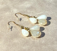 Load image into Gallery viewer, Pair of earrings with white teardrop-shaped stones on a light background