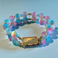 Load image into Gallery viewer, Multicolored beaded bracelet with a gold clasp on a light blue background
