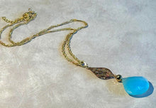 Load image into Gallery viewer, Necklace with a blue pendant on a light gray background
