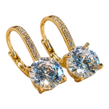 Load image into Gallery viewer, A pair of gold leverback earrings with round-cut clear gemstones and pavé-set accent stones along the hoops, shown on a plain white background.
