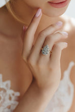 Load image into Gallery viewer, Close-up of a hand wearing a labradorite gemstone ring with a soft focus background
