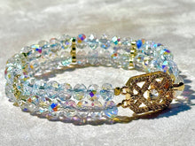 Load image into Gallery viewer, Multistrand beaded bracelet with gold clasp on a textured surface

