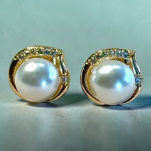 Load image into Gallery viewer, Pair of pearl earrings with gold and gemstone accents on a light blue background
