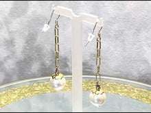 Load and play video in Gallery viewer, Video of long white pearl earrings in gold
