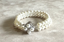 Load image into Gallery viewer, Pearl bracelet with a silver clasp on a textured surface
